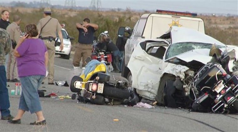 In this photo taken from video made Saturday, rescuers and victims are seen at the site of a collision involving a car and several motorcycles on a remote desert highway near Ocotillo, Calif. 